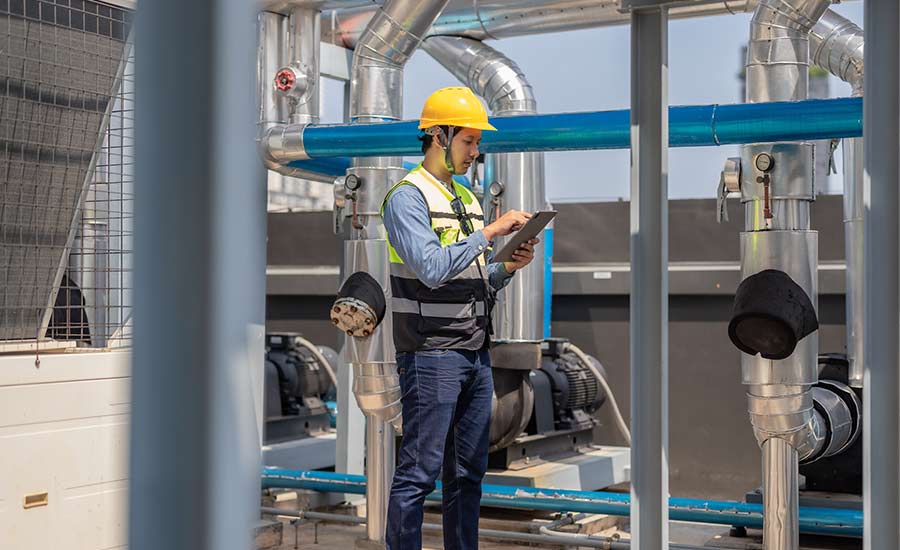 An HVAC technician conducting an inspection on a tablet​