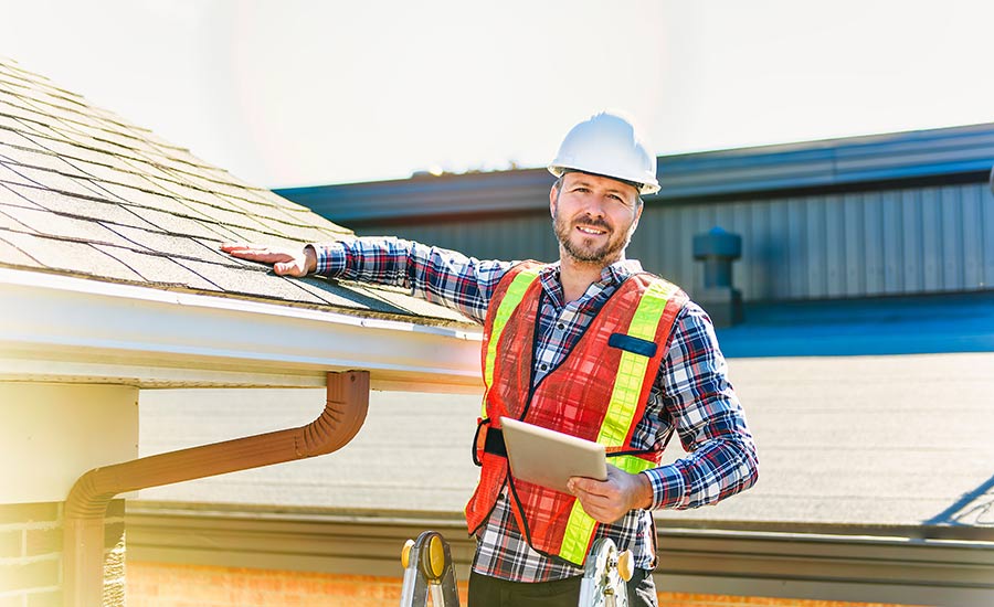 A home inspector checks the roof of a house​