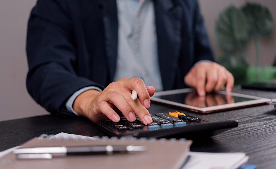 A business owner calculating finances on a tablet​